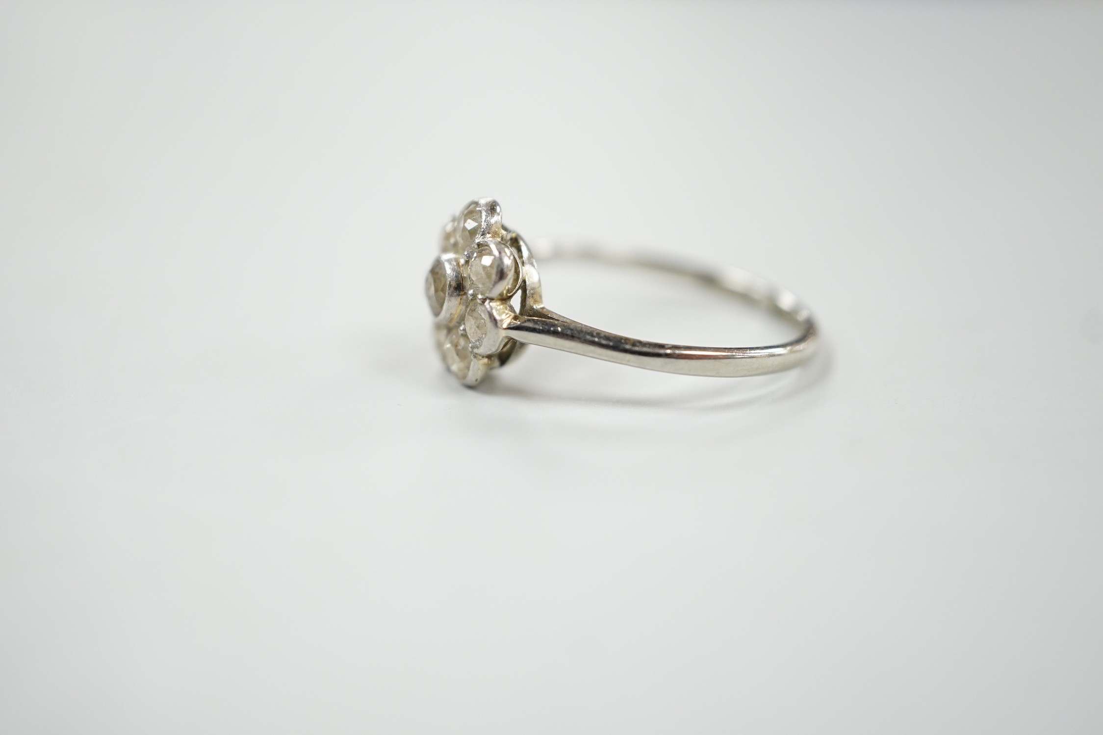 A 1920's 18ct, plat and millegrain set diamond flower head cluster ring, size O, gross weight 2.2 grams.